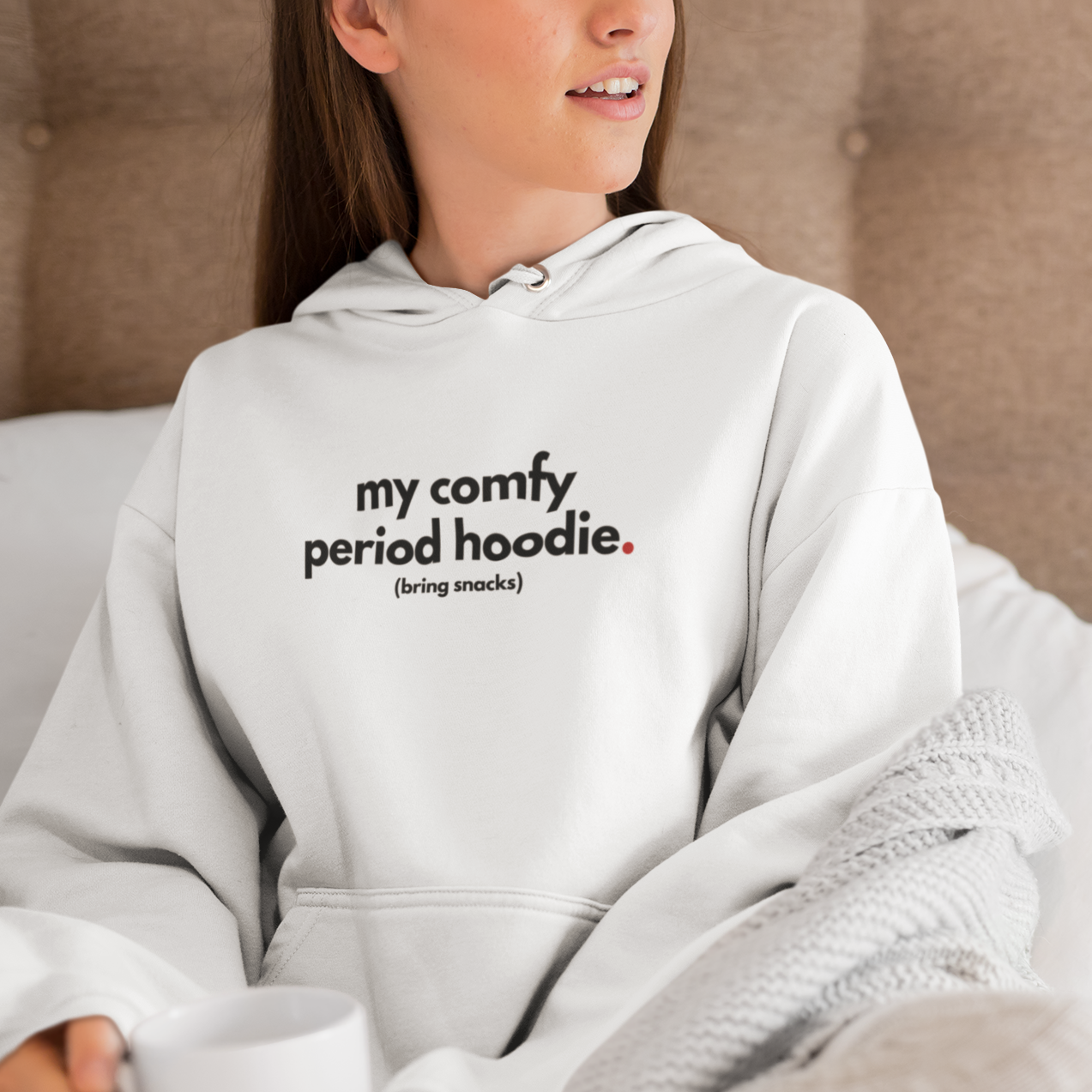 pullover-hoodie-mockup-of-a-young-woman-sitting-on-a-bed-with-a-coffee-mug-23212.png